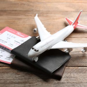 Toy airplane and passports with tickets on wooden background